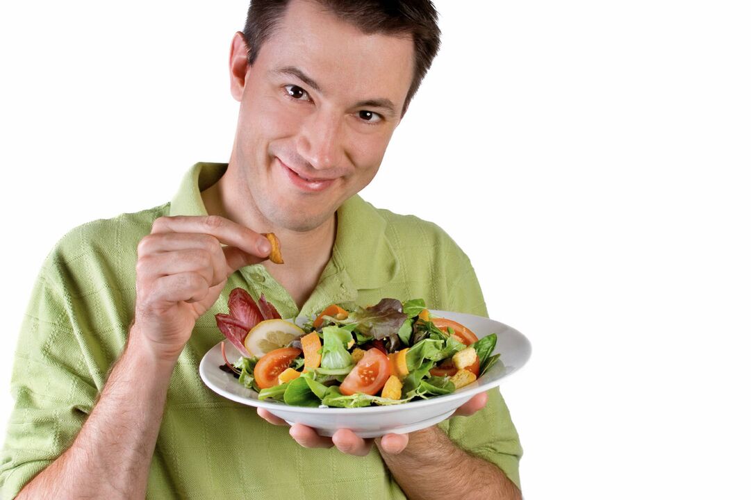 L'homme mange de la salade de légumes pour la puissance